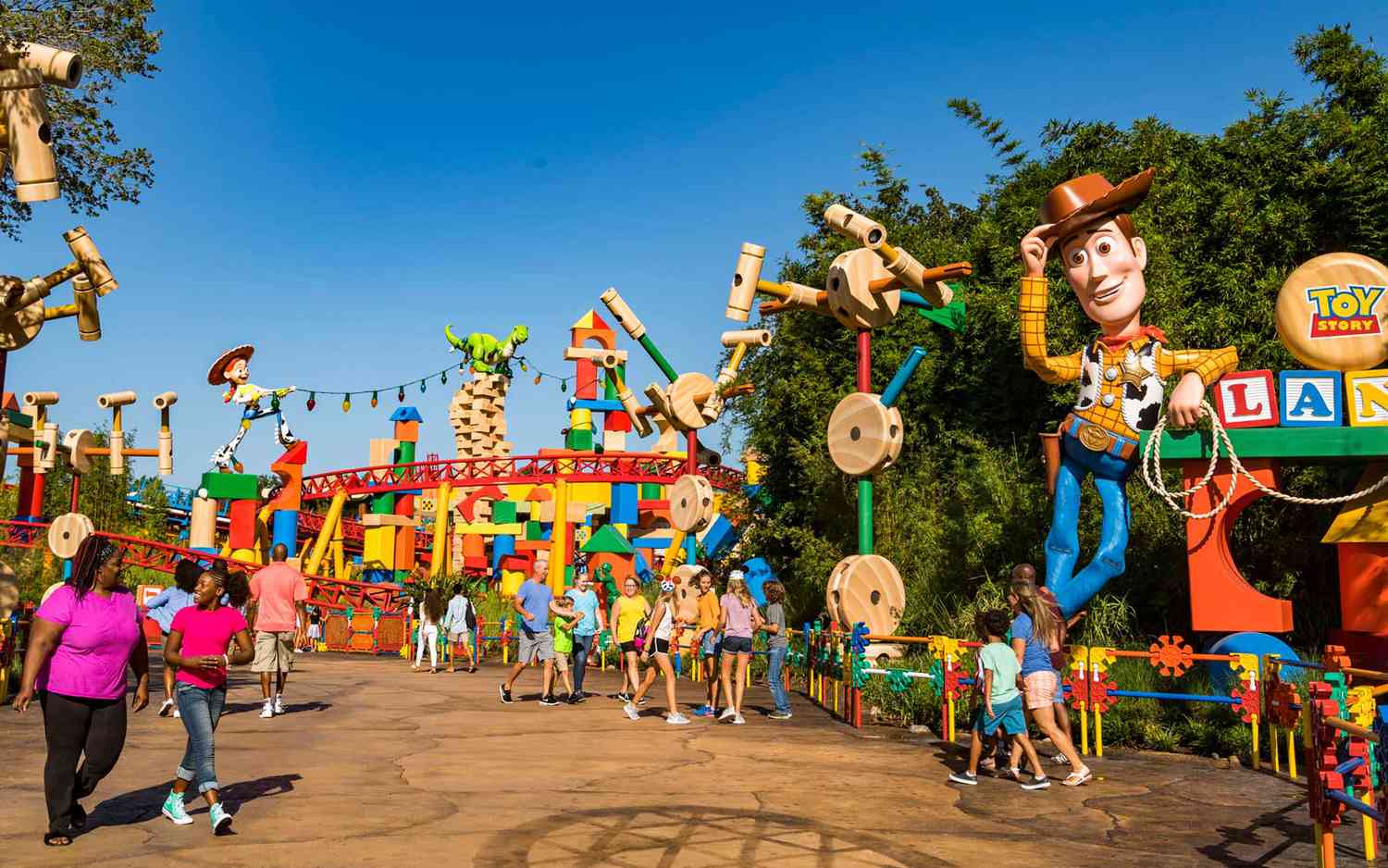 Visão colorida de Toy Story Land no Disney's Hollywood Studios em Orlando, com uma estátua do Woody e diversos brinquedos gigantes em um ambiente vibrante e alegre.